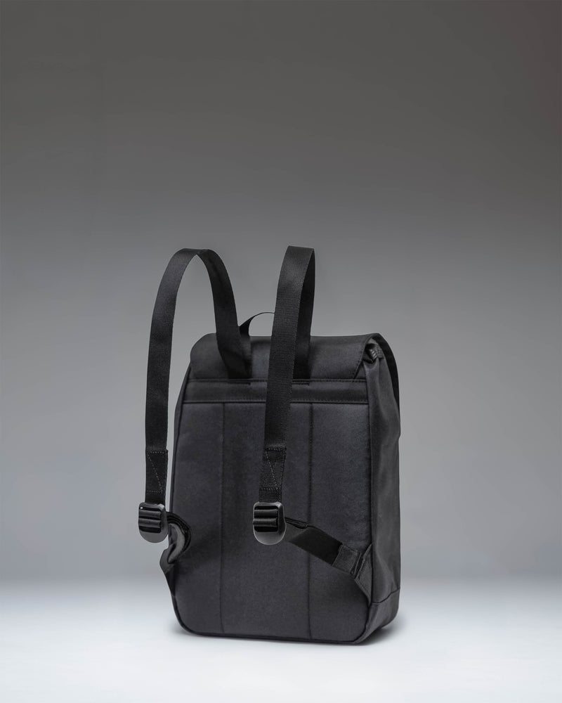 Herschel Retreat Mini Backpack in solid black, featuring dual rubber straps with magnetic pin clips and a woven classic brand label.