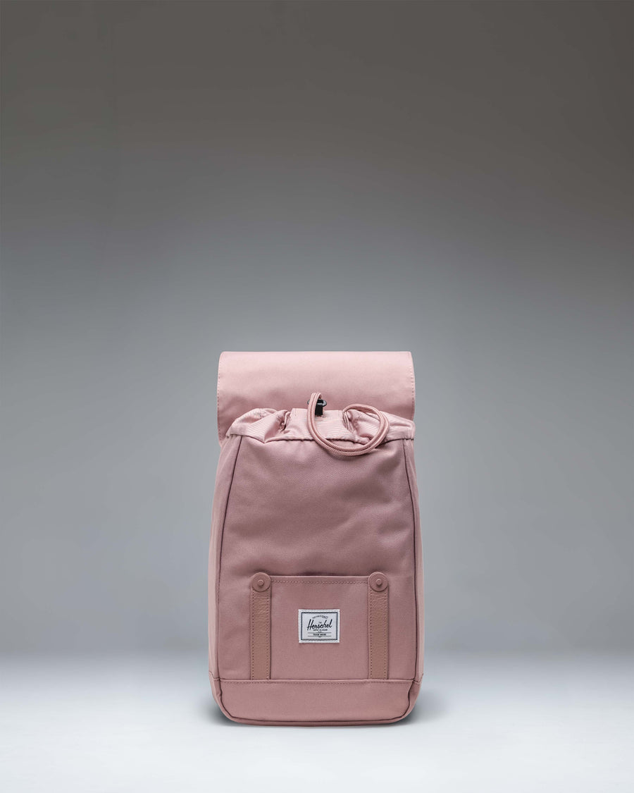 Herschel Retreat Mini Backpack in Ash Rose featuring a drawcord closure and magnet-fastened straps with buckles.