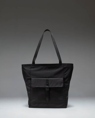 Herschel Retreat Tote bag in black, showcasing its clean design, dual carrying handles, and classic woven label on the front.