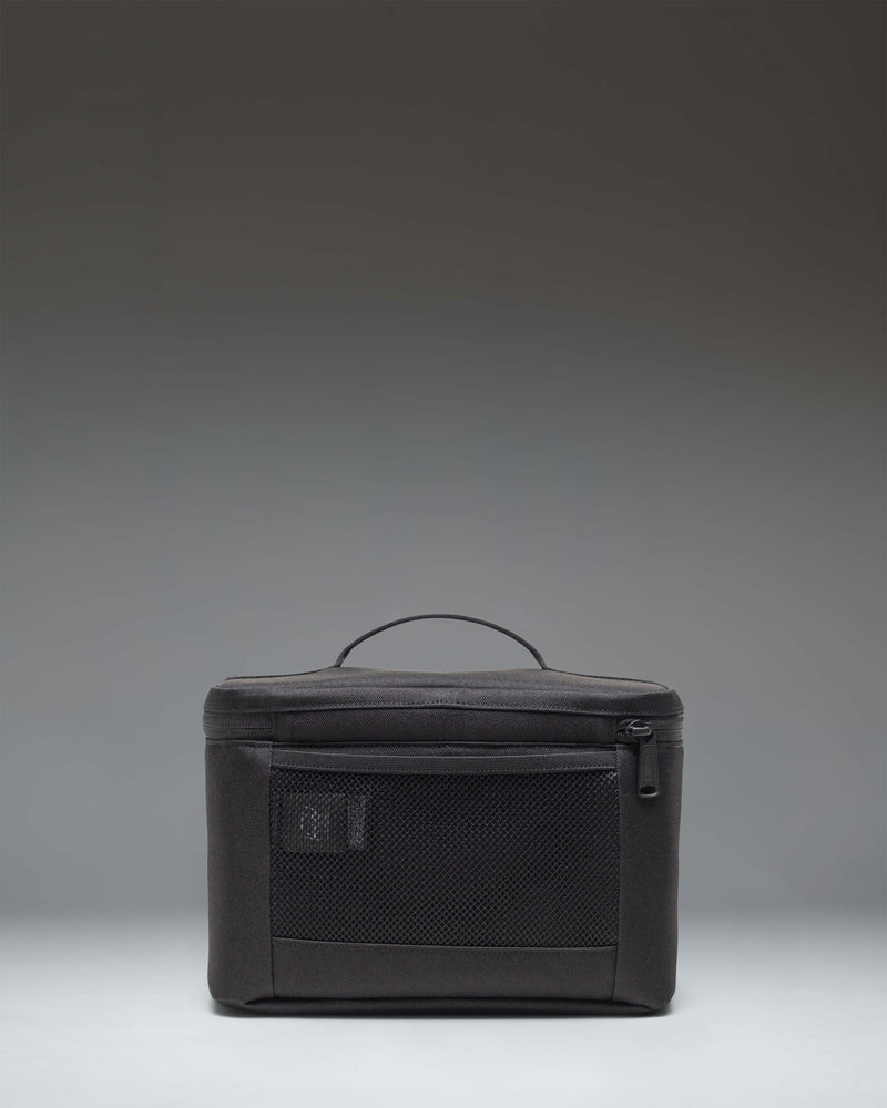 Black Herschel Heritage Lunch Box shown from an angled lifestyle view, highlighting its classic design and structured shape.