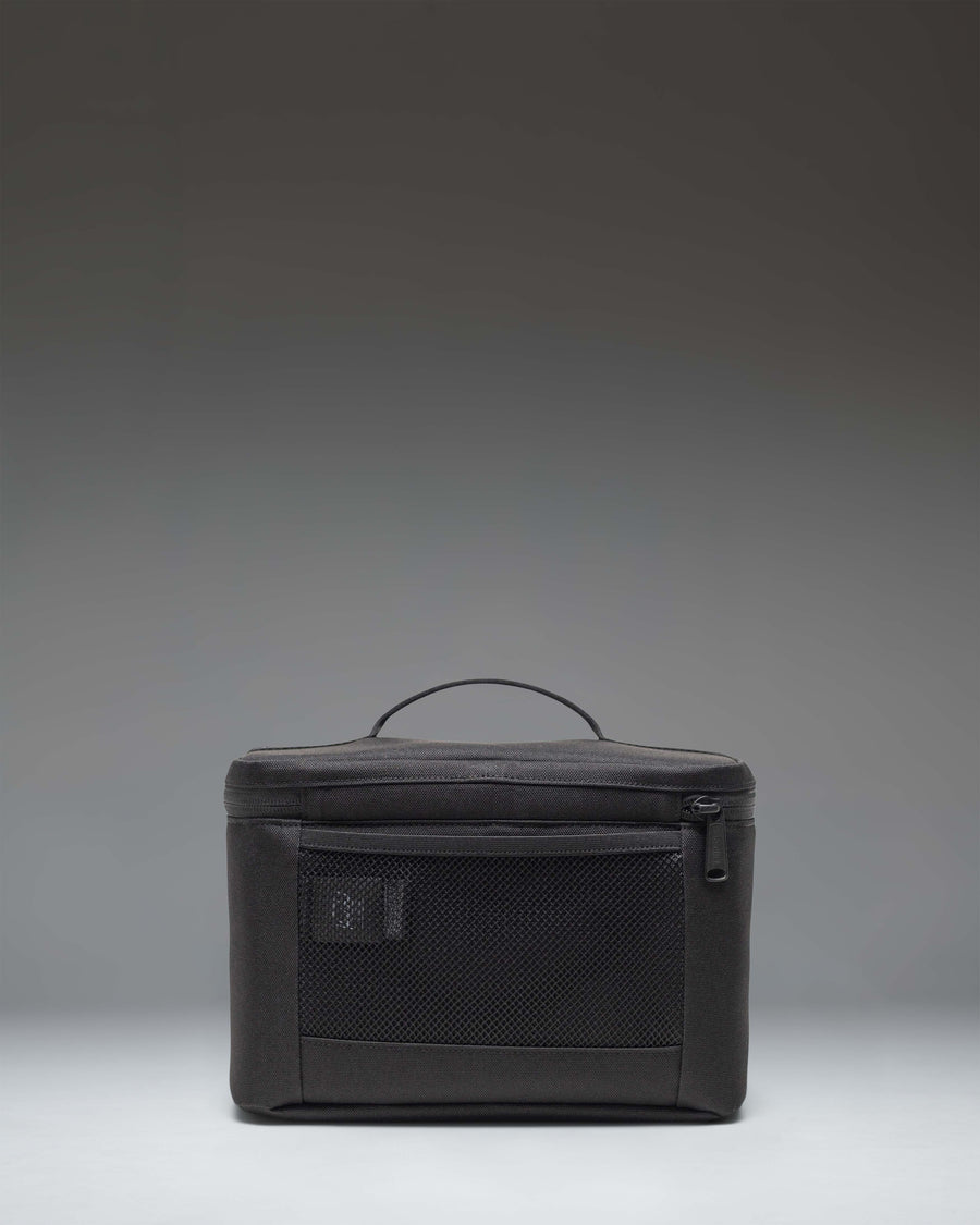 Black Herschel Heritage Lunch Box shown from an angled lifestyle view, highlighting its classic design and structured shape.