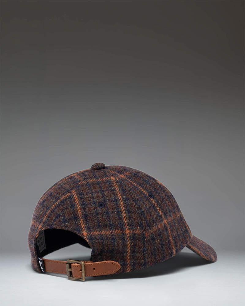 Herschel Supply Co. Heritage backpack in Dark Plaid/Tan, featuring a dark plaid pattern with a tan diamond detail and bottom accent.