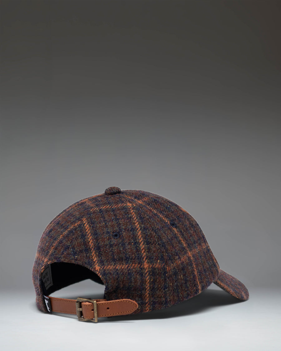 Herschel Supply Co. Heritage backpack in Dark Plaid/Tan, featuring a dark plaid pattern with a tan diamond detail and bottom accent.