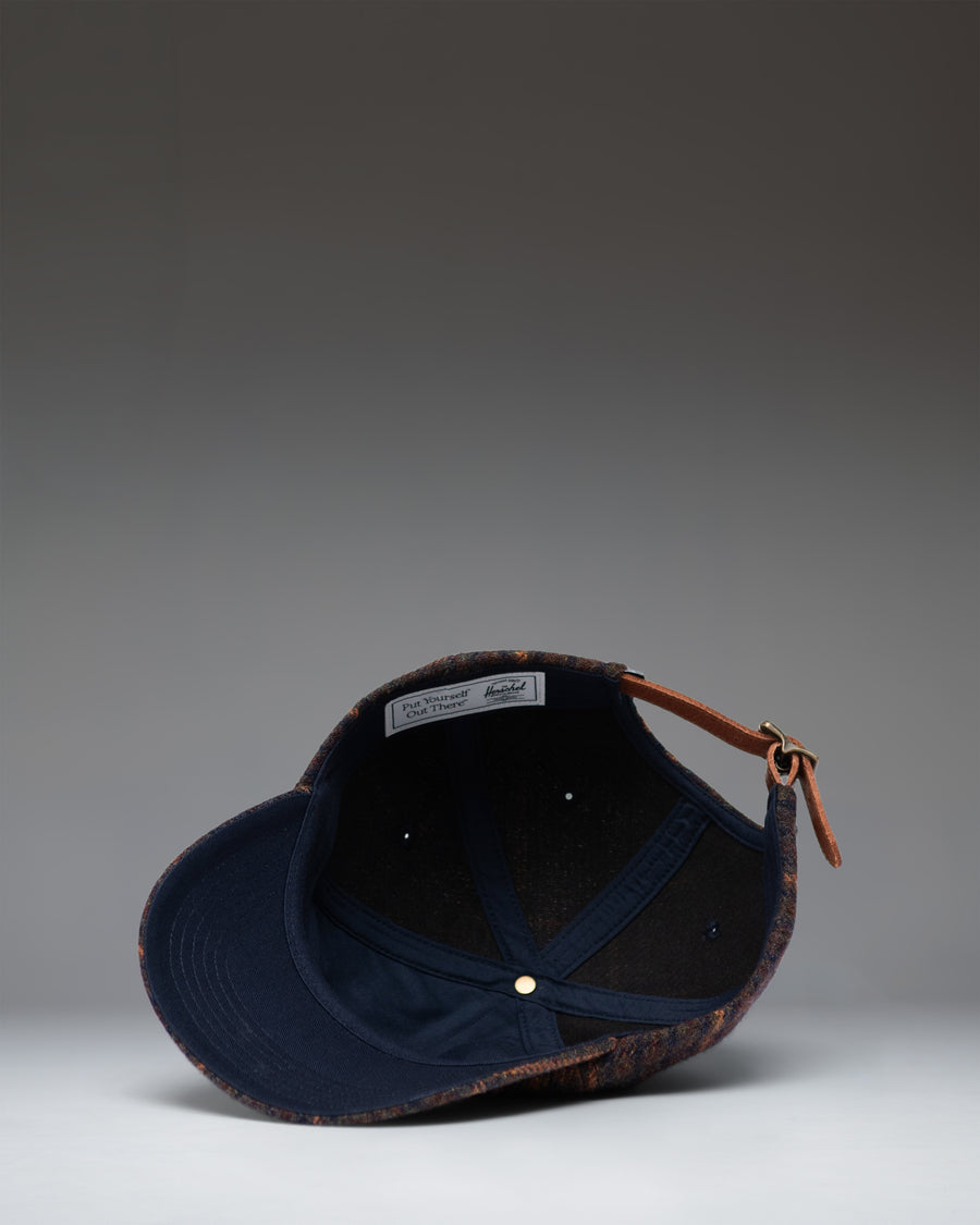 Dark Plaid and Tan Herschel Supply Co backpack lifestyle view showing the front, straps, and clean classic design.