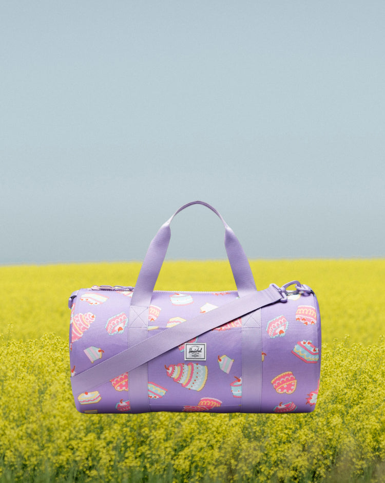 Herschel Classic Duffle Little Herschel in Cakes colorway, featuring a whimsical pastry and sweets pattern.