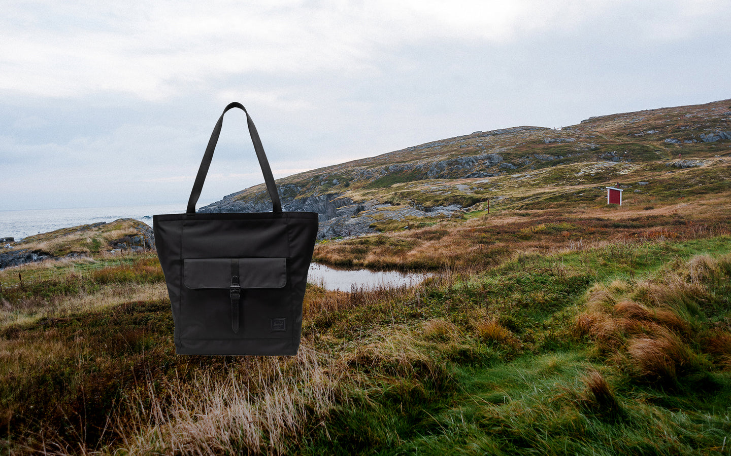 Black Herschel Retreat Tote shown from the front on a desktop view.