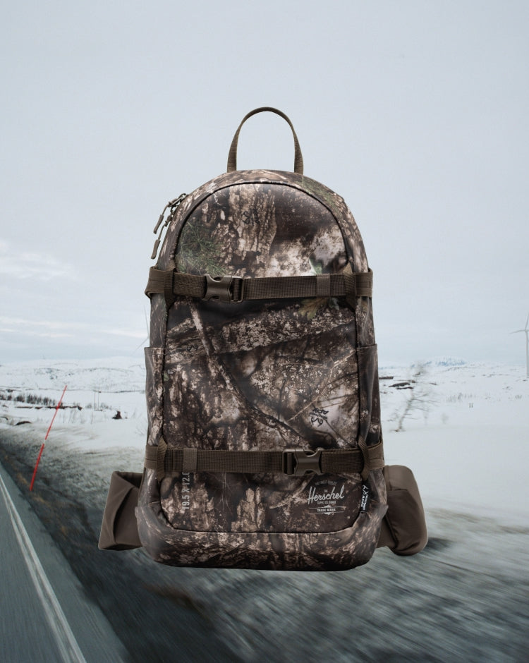 Herschel Supply Co. Realtree All Season Resort Backpack 14L in Realtree APX Camo pattern, mobile hero view.