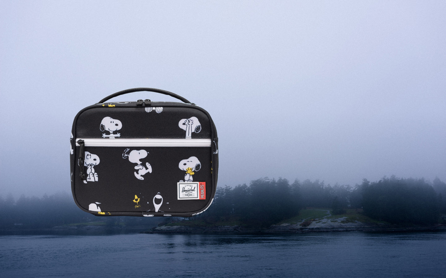 Herschel Supply Co. Peanuts Pop Quiz Lunch Box in Snoopy and Woodstock Black featuring a Snoopy patch on a black background.